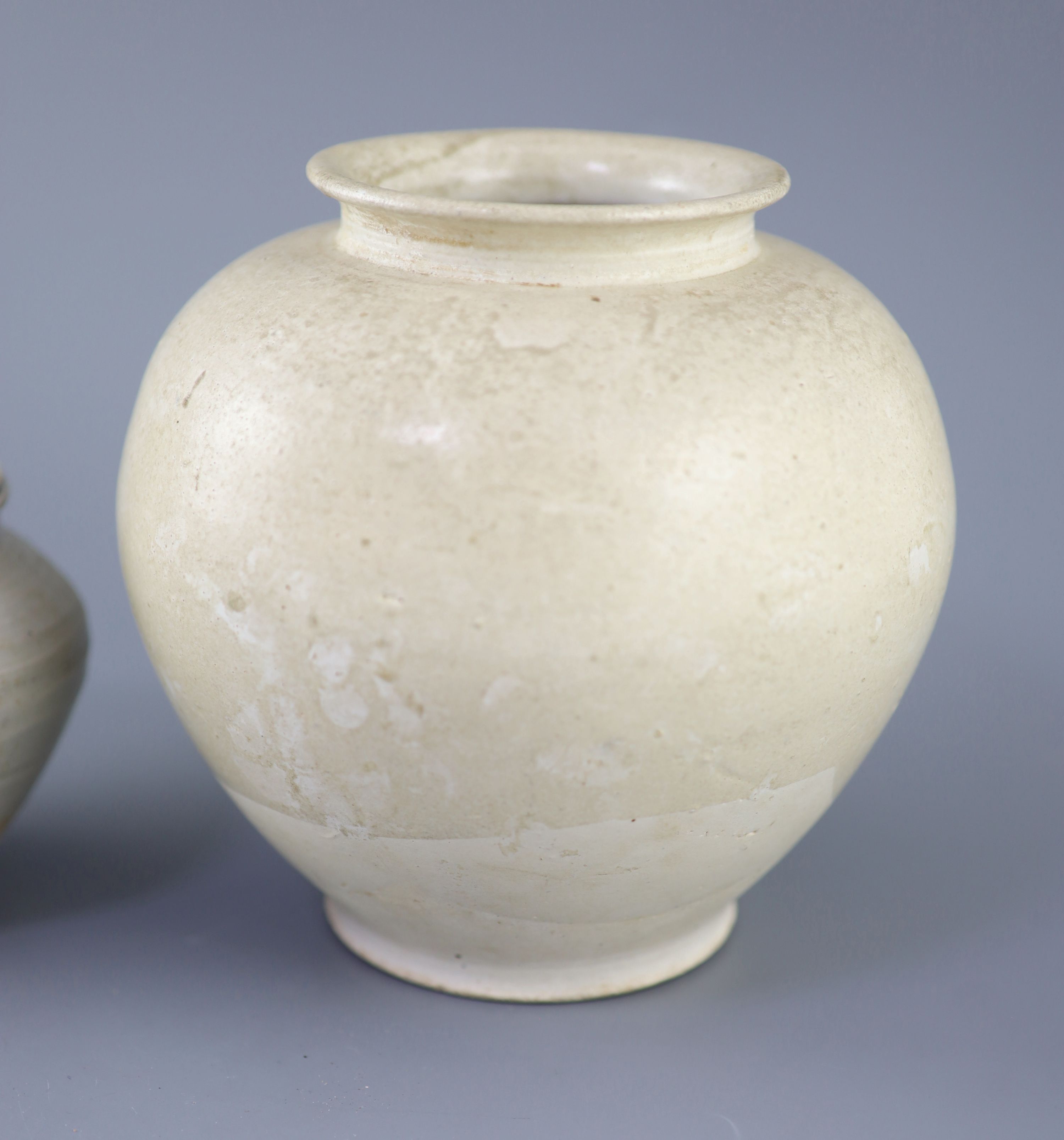 A Chinese cream glazed ovoid jar, Tang dynasty and a Ding type jar and cover, Yuan dynasty,